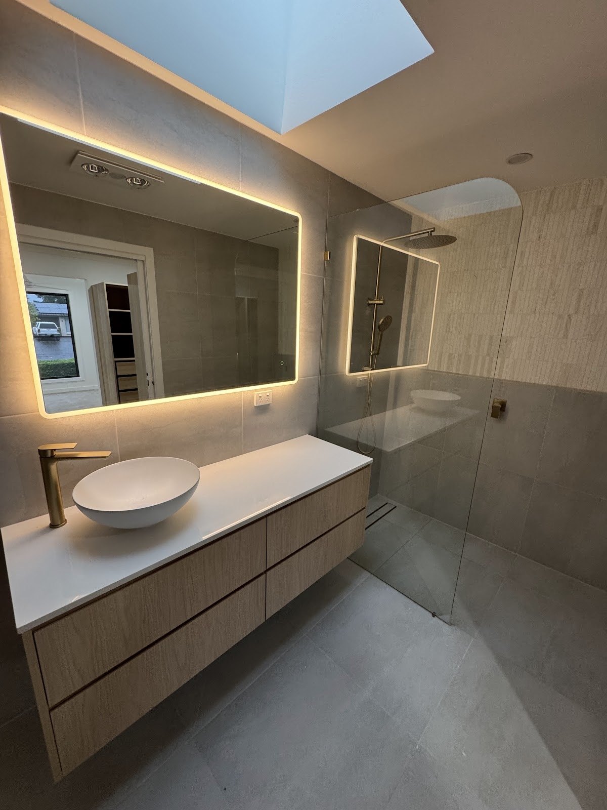 Ensuite renovation with backlit mirror and floating timber vanity
